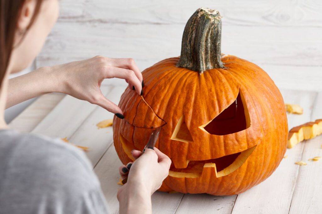 Carving halloween pumpkin into jack-o-lantern, close up view