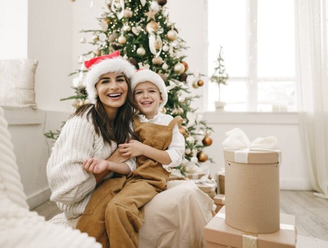 Portrait of happy mother and her son celebrate Christmas in festively decorated room