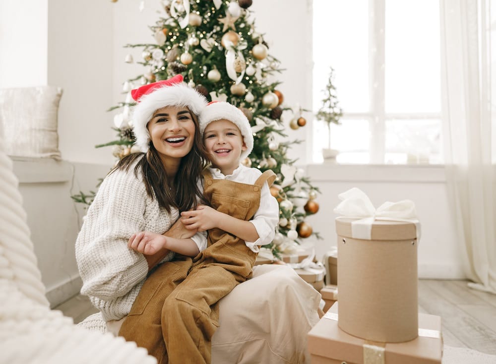 Portrait of happy mother and her son celebrate Christmas in festively decorated room